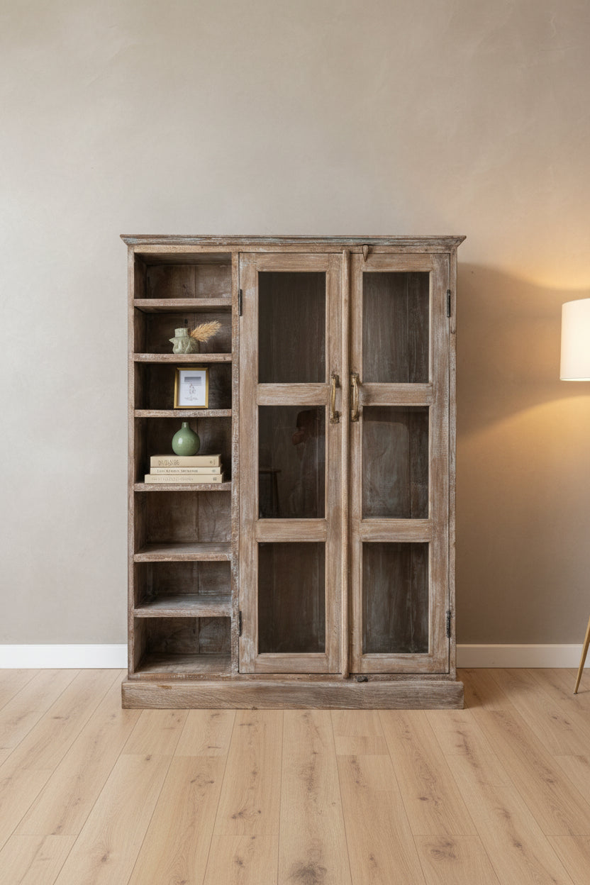 A rustic, distressed wooden bookcase and cabinet with two glass-paneled doors and open shelves on the left, photographed in a cluttered workshop or storage room.