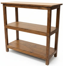 A rustic two-tier wooden console table with a warm medium-brown finish, set in a cluttered antique shop or furniture showroom with other vintage items in the background.