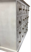 Wooden dresser with multiple drawers and decorative handles on a white background