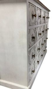 Wooden dresser with multiple drawers and decorative handles on a white background